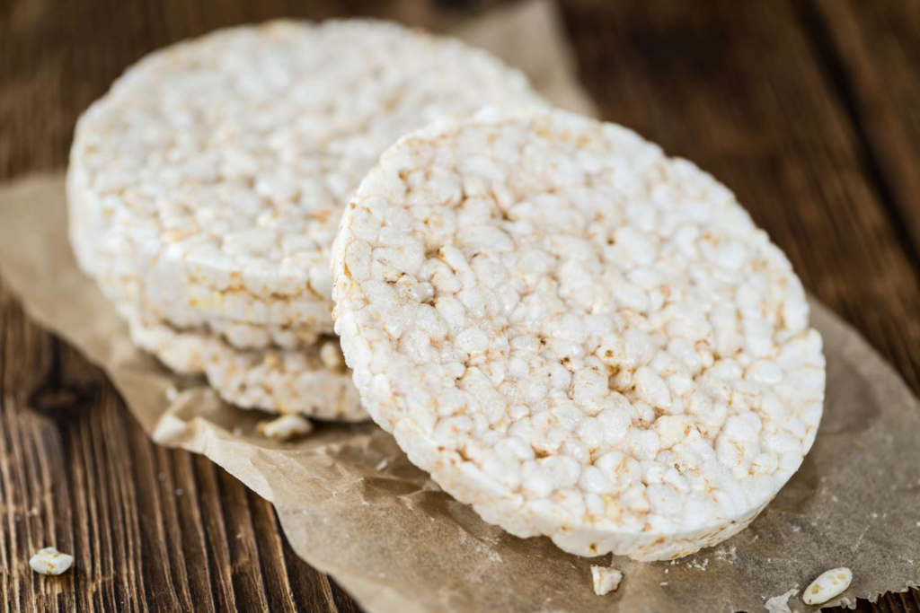 Round rice chips stacked on parchment on a rustic wooden table